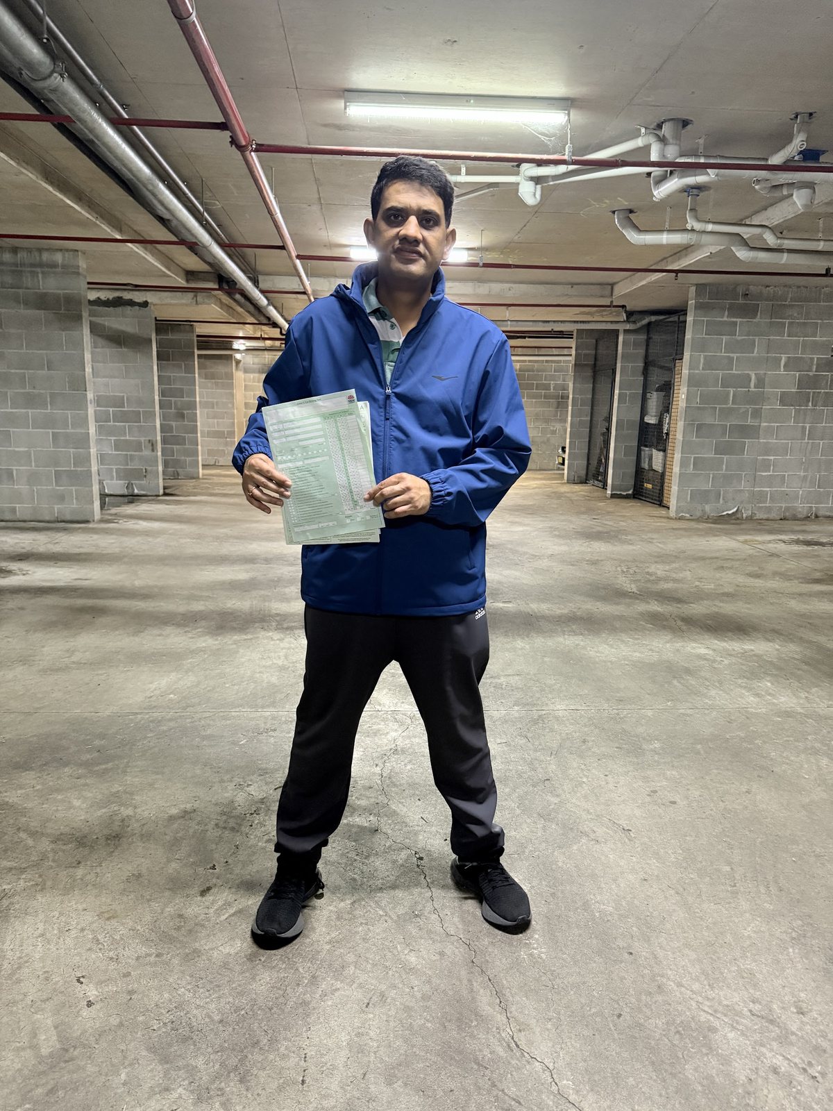 A student holding a driving test result sheet