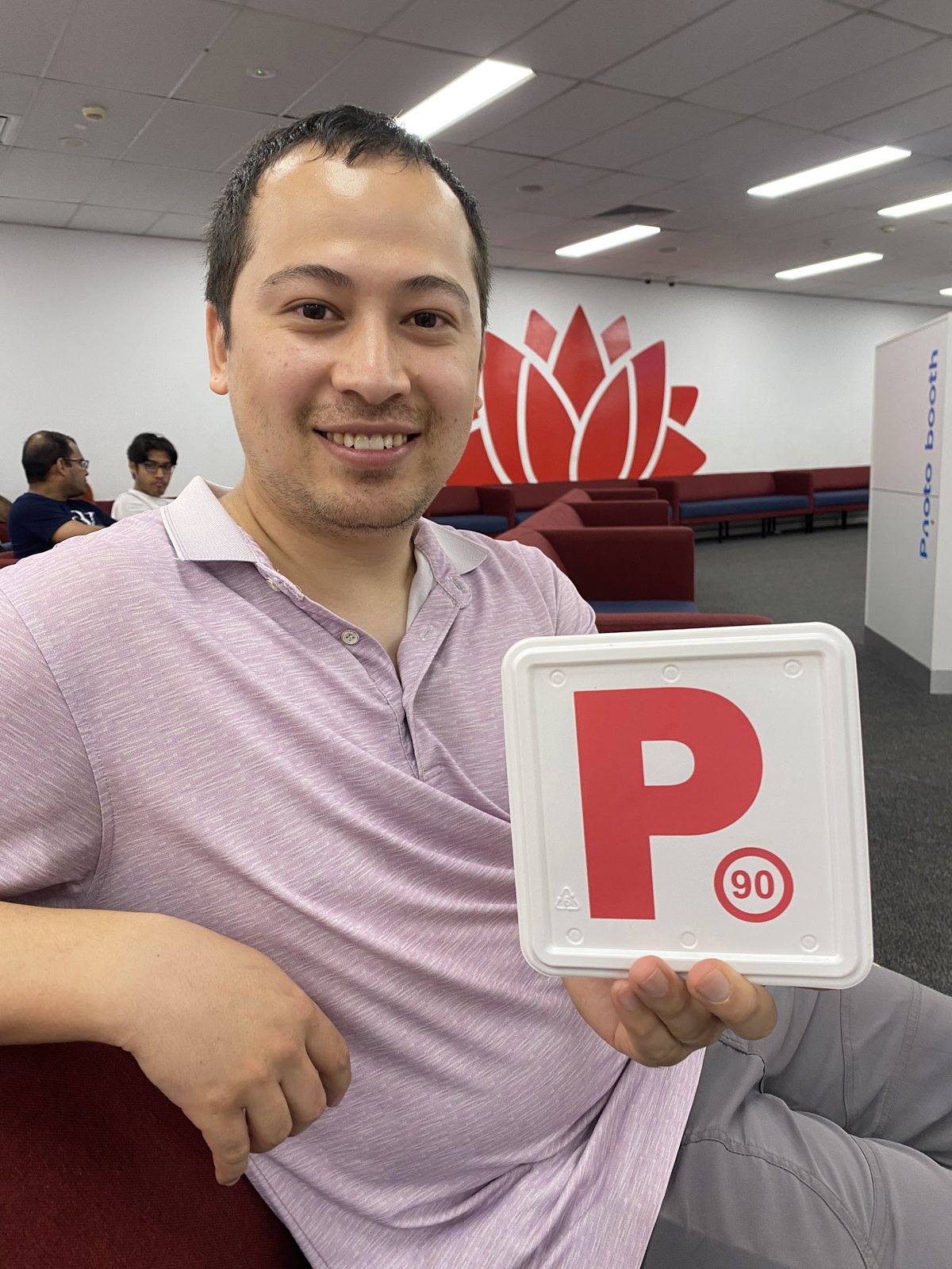 A student smiling with a new red P-plate at the service centre