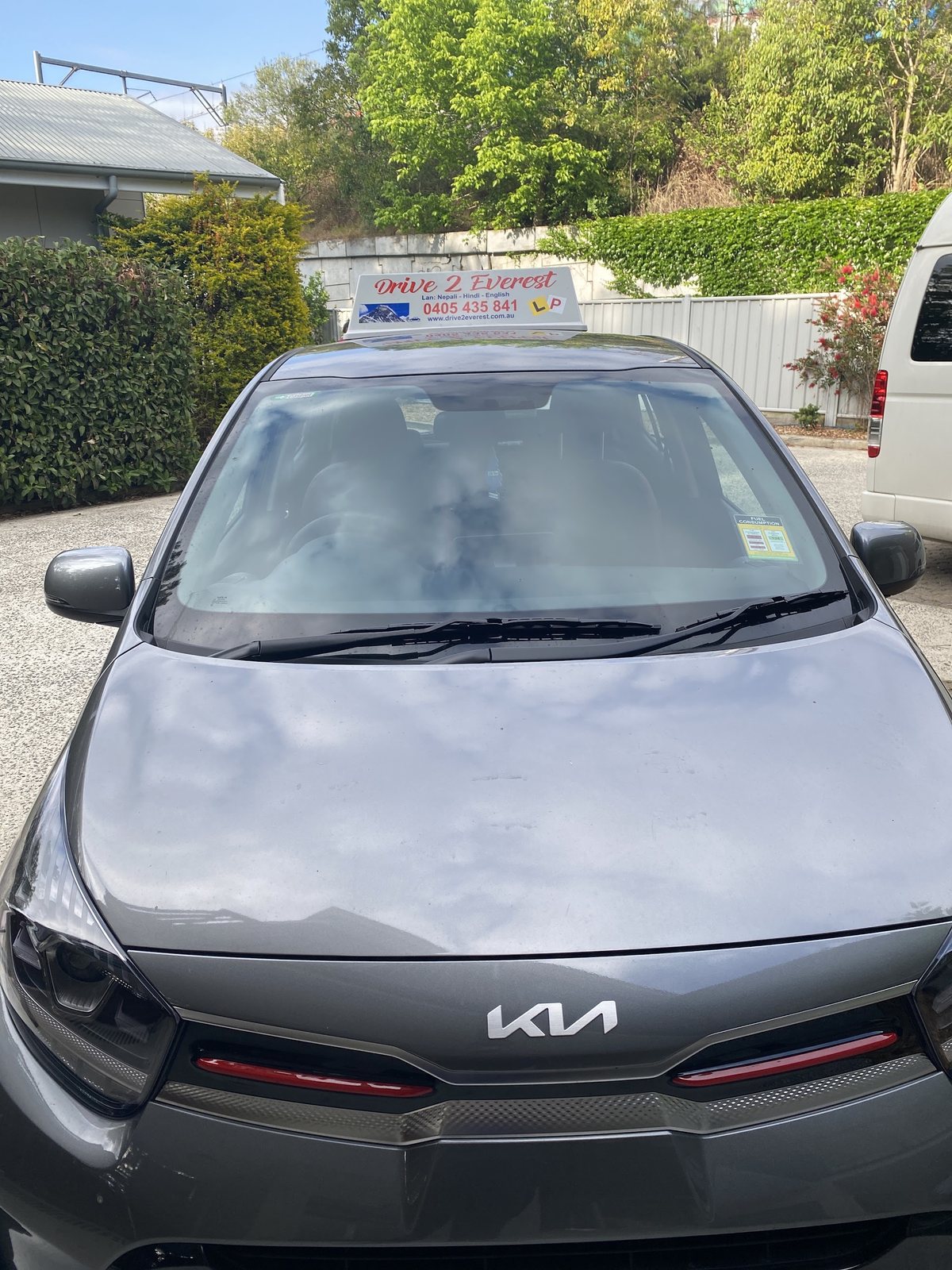 Front view of the grey Drive 2 Everest Kia Picanto with the school sign on the roof